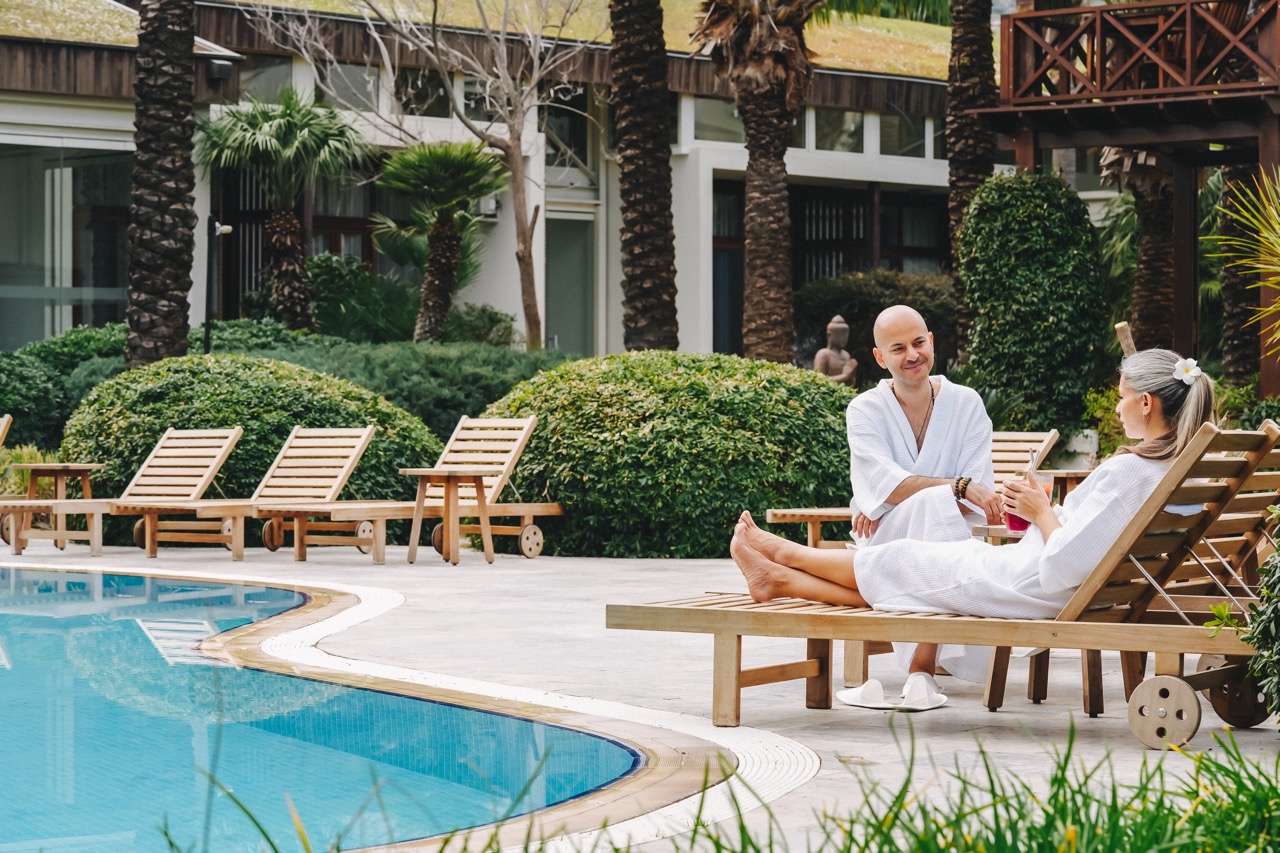 Happy guests sitting and relaxing by the pool